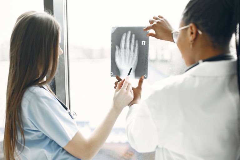 A pediatric patient and a pediatric doctor looking a hand x ray.